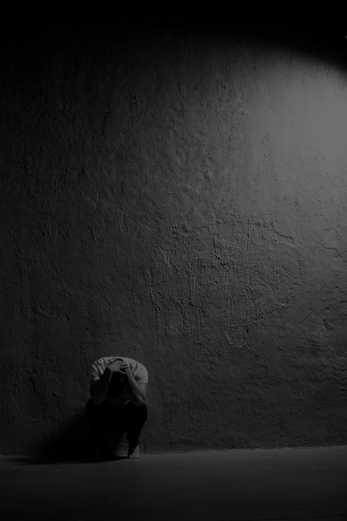 Solitary figure in shadow representing addiction and recovery through a cracked lens of perception